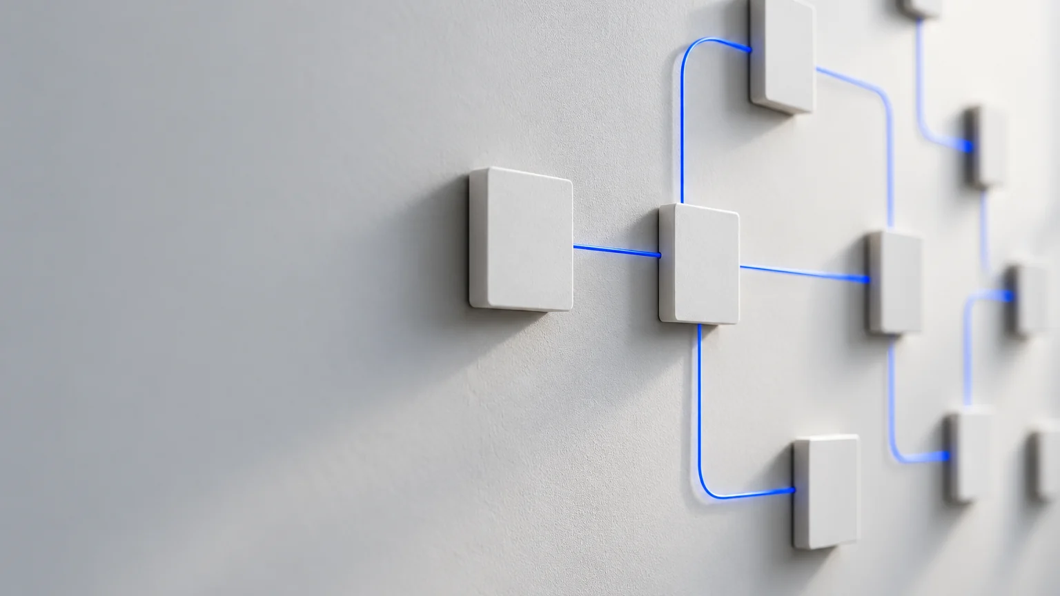 Petites tuiles blanches reliées par de fines lignes bleues comme un schéma de processus sur un mur gris clair