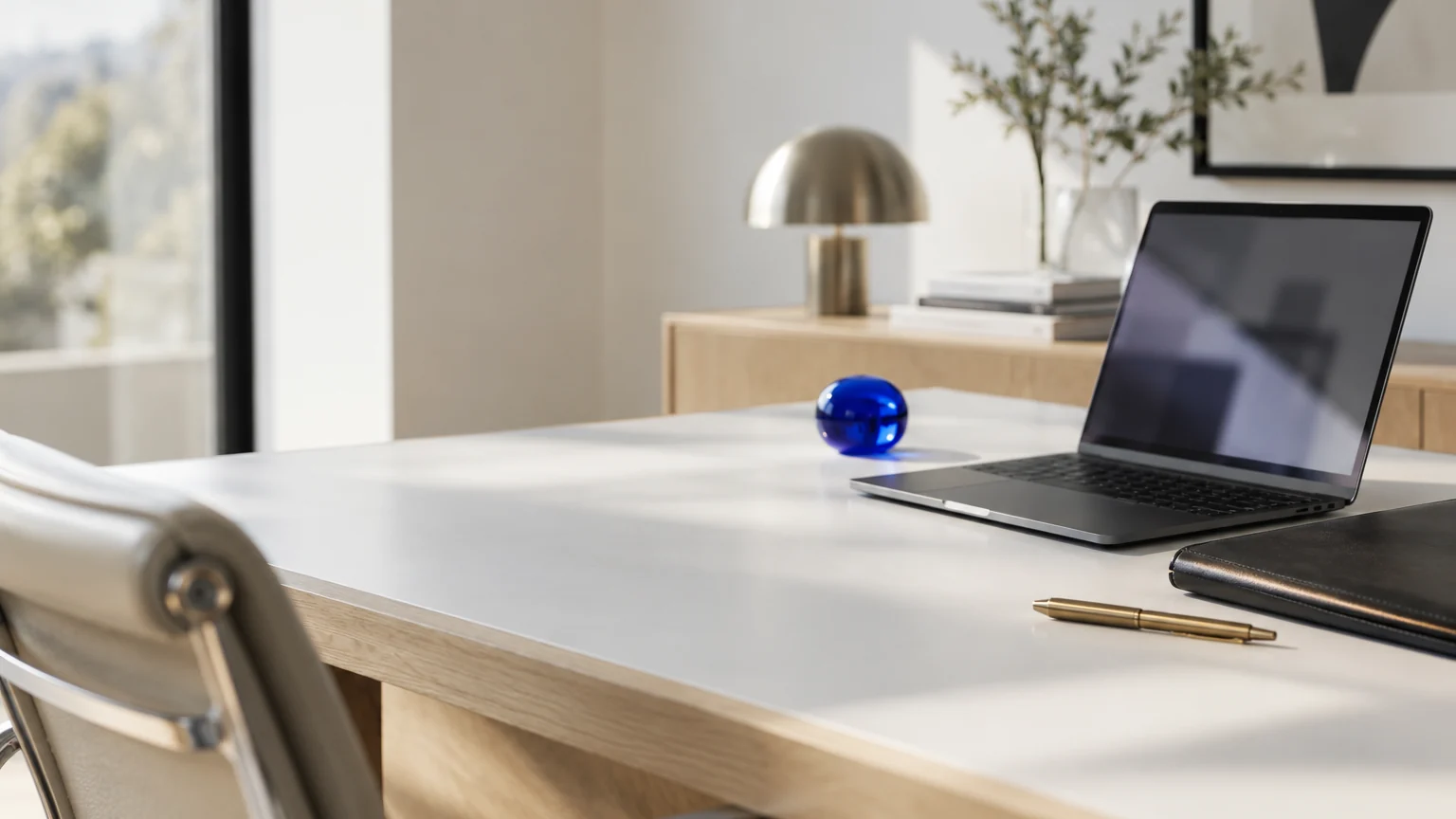 Bureau d'avocat sobre avec un ordinateur portable, un dossier fermé et un presse-papier en verre bleu