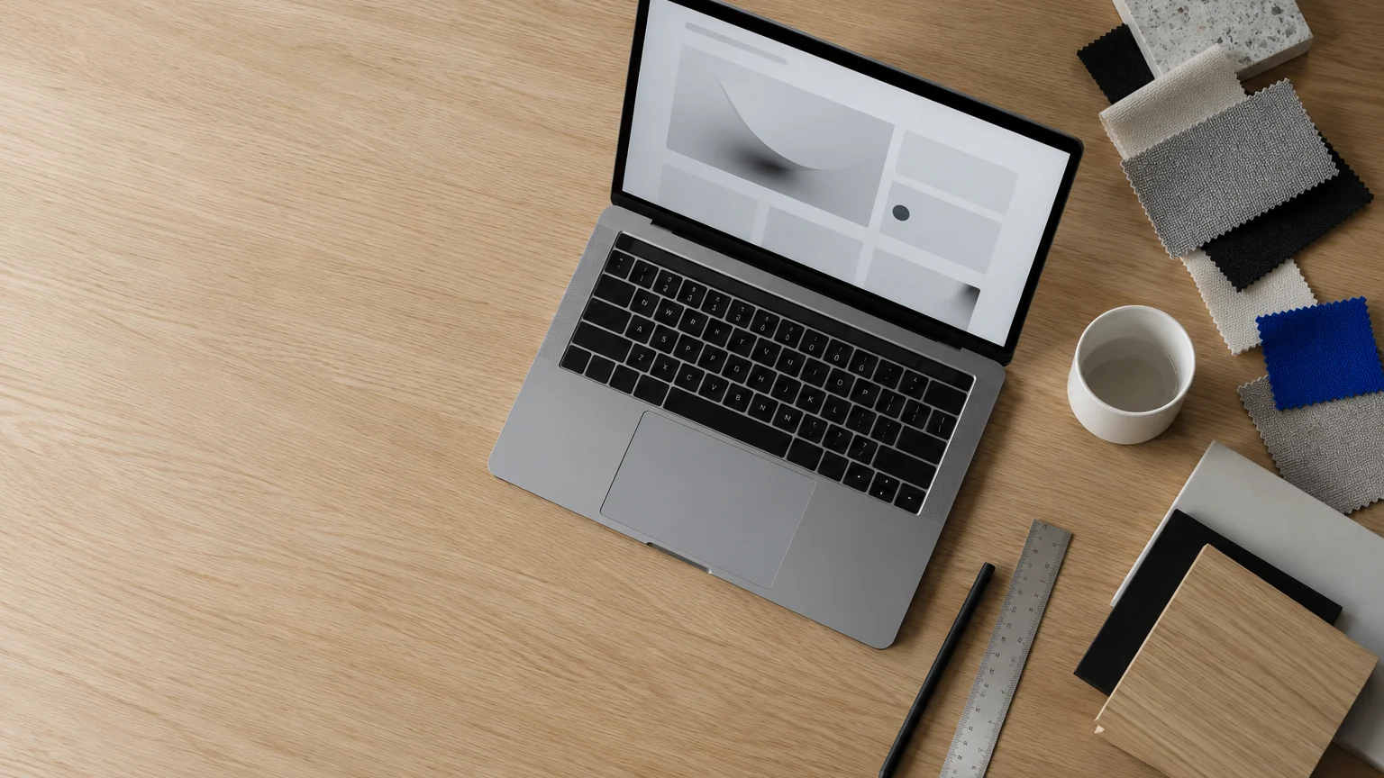 Bureau de designer vu de dessus avec un ordinateur portable, des échantillons de couleurs et une règle