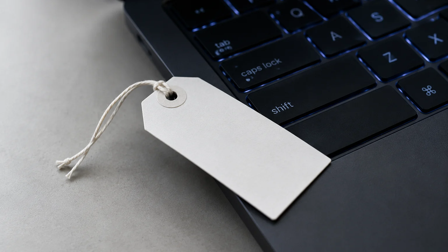 Étiquette blanche vierge posée sur un clavier noir avec un rétroéclairage bleu
