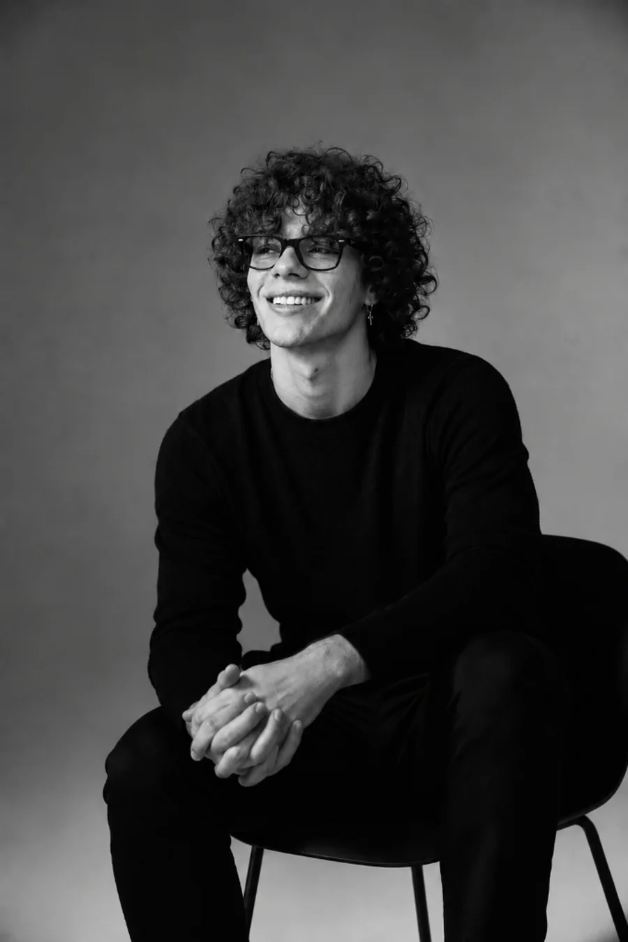 Enzo Da Silva, co-founder of the Re:solve web agency: smiling studio portrait in a dark sweater