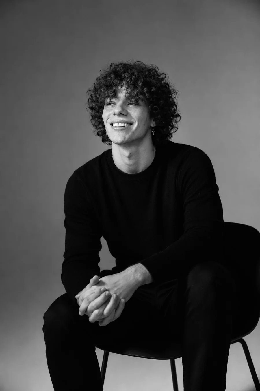 Studio portrait, smiling, in a dark sweater